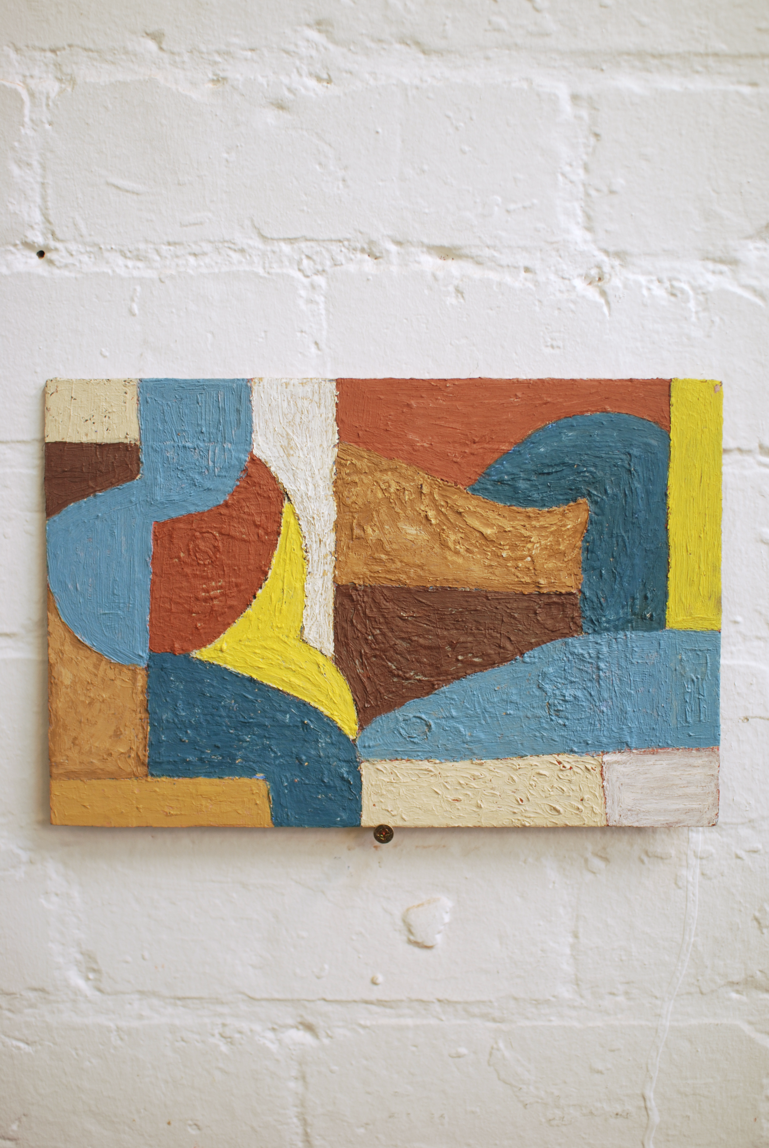 Abstract painting with geometric shapes on a textured wall