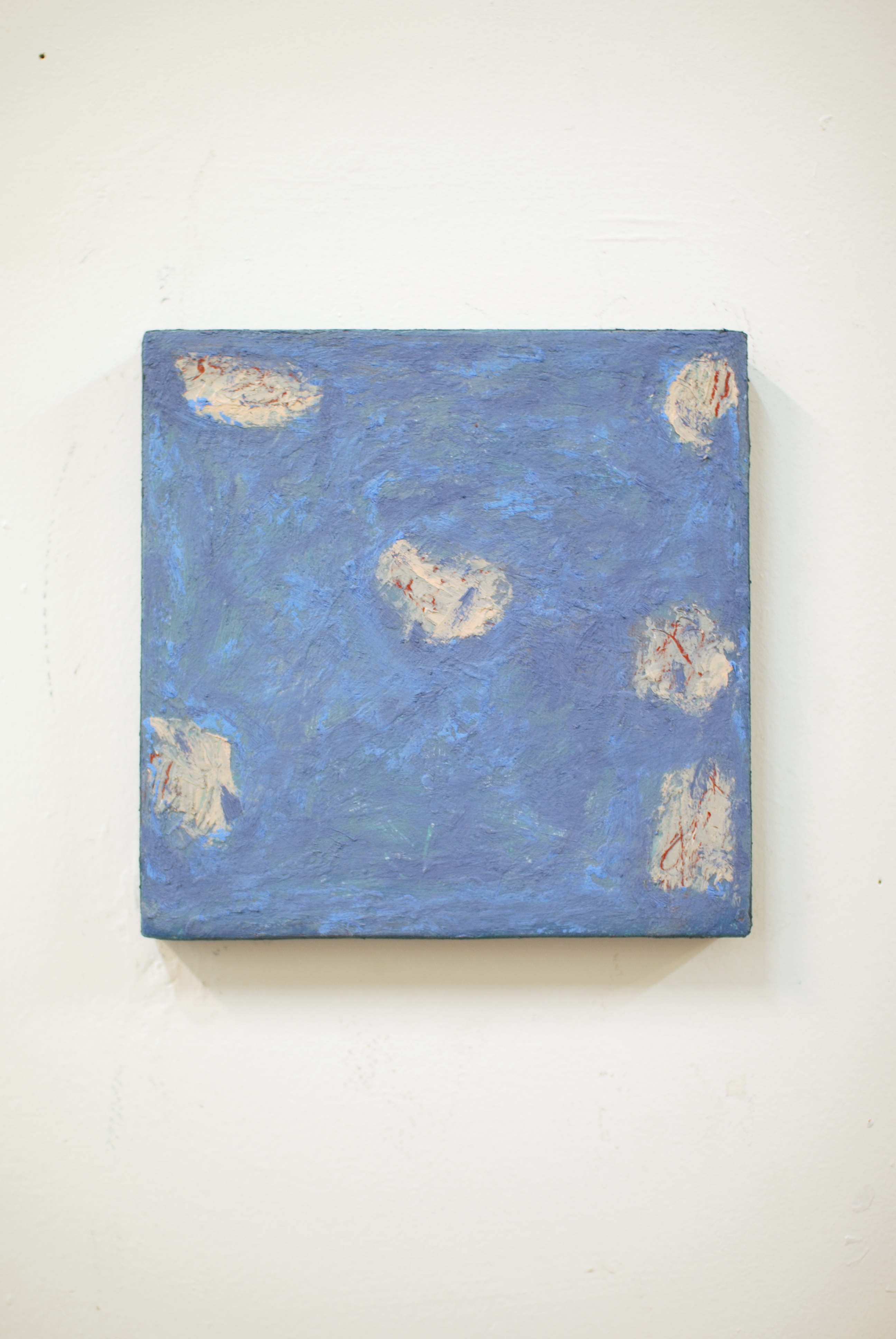 Blue textured painting with abstract patterns on a white wall