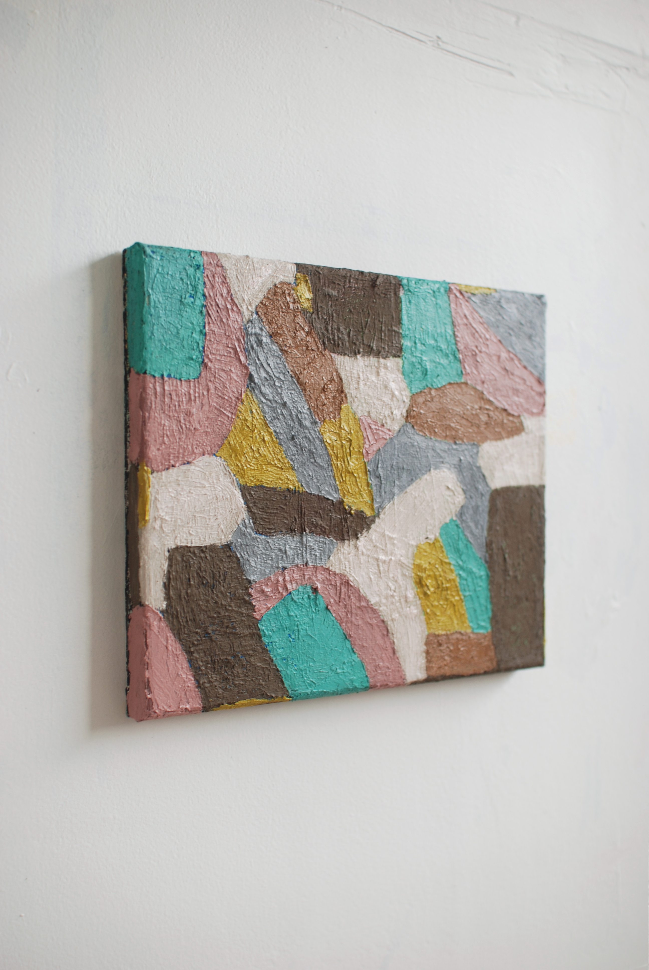 Abstract multicolored textured artwork on a white wall